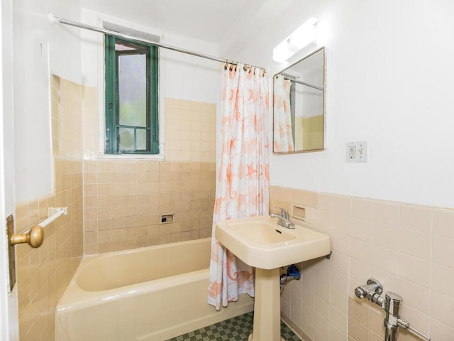 bathroom with shower / tub combo, wainscoting, and tile walls