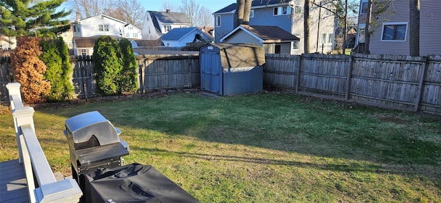 view of yard with a fenced backyard, an outdoor structure, a residential view, and a storage unit