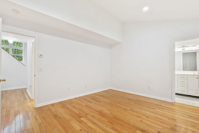 unfurnished bedroom featuring light wood finished floors, baseboards, connected bathroom, and recessed lighting