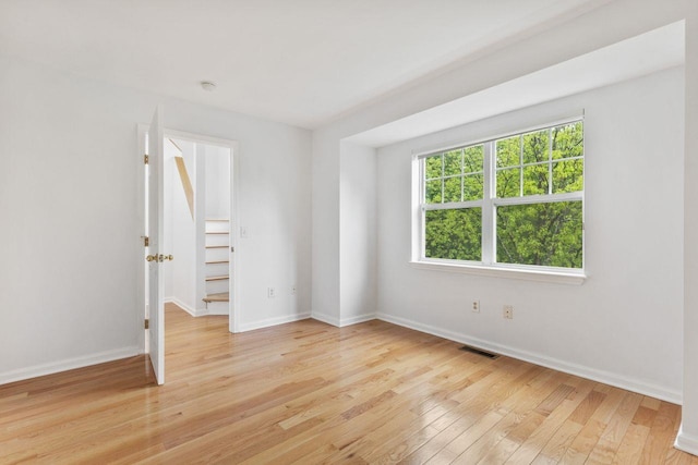 spare room featuring light wood finished floors and baseboards