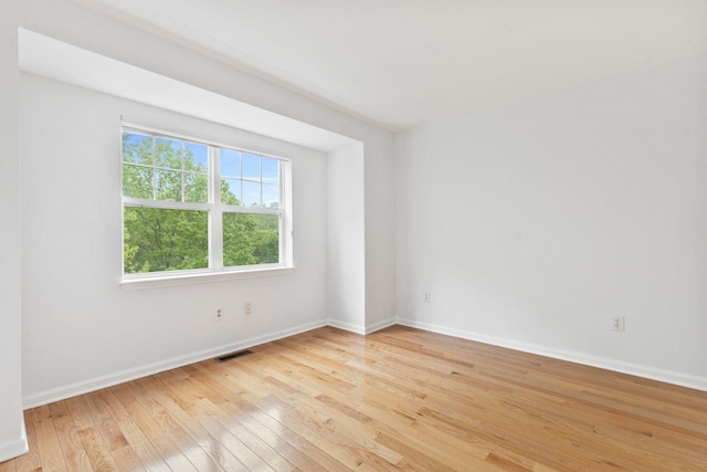 spare room with hardwood / wood-style flooring and baseboards