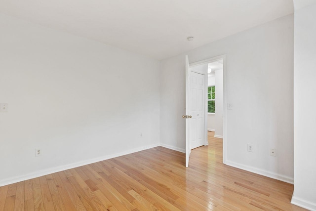 empty room with light wood-type flooring and baseboards