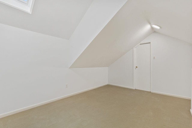 bonus room featuring lofted ceiling, light carpet, and baseboards