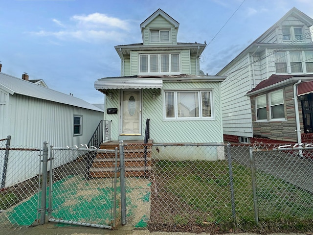 view of front of house featuring a fenced front yard, a front lawn, and a gate