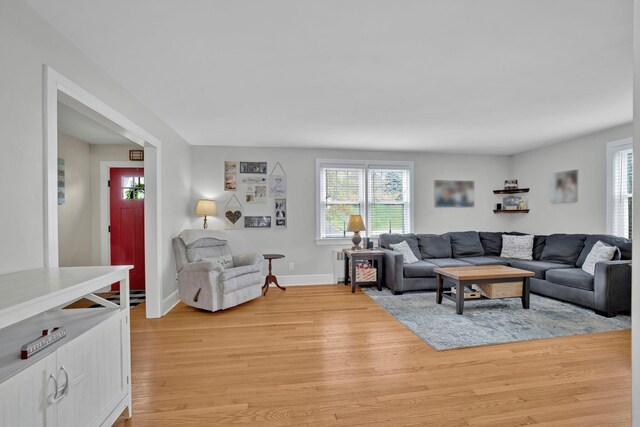 living room with baseboards, a healthy amount of sunlight, and light wood-style floors
