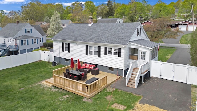 back of house featuring outdoor lounge area, a wooden deck, a fenced backyard, a gate, and a yard