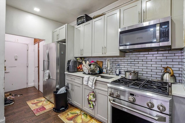 kitchen with decorative backsplash, stainless steel appliances, light countertops, and a sink
