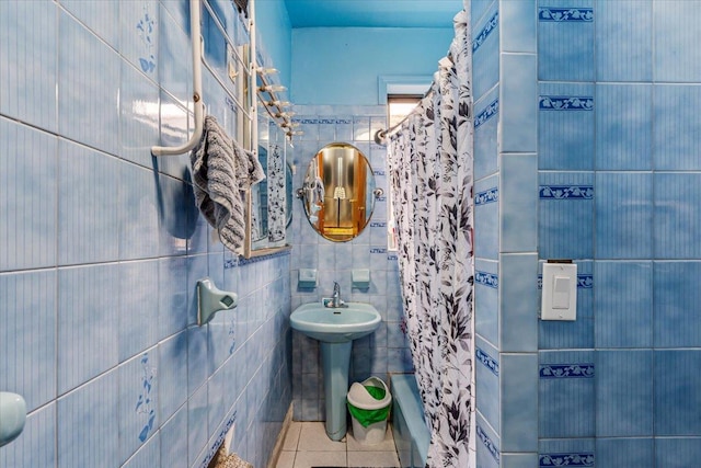 full bathroom featuring curtained shower, tile walls, and tile patterned floors
