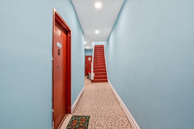 hall featuring baseboards, recessed lighting, and stairs