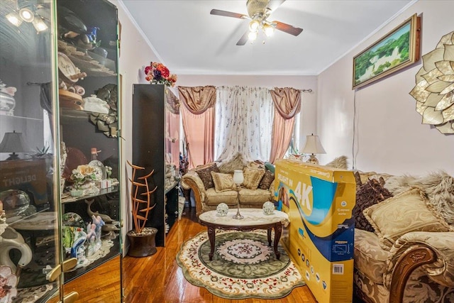 sitting room with wood finished floors, ceiling fan, and ornamental molding