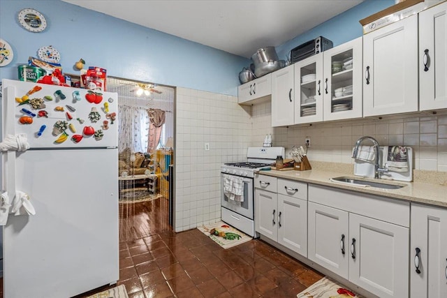 kitchen with white cabinets, white appliances, glass insert cabinets, and a sink
