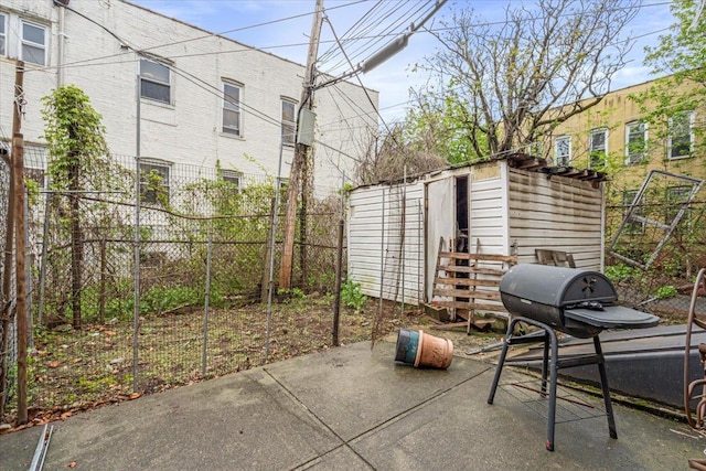 view of patio / terrace featuring an outbuilding, a shed, area for grilling, and fence