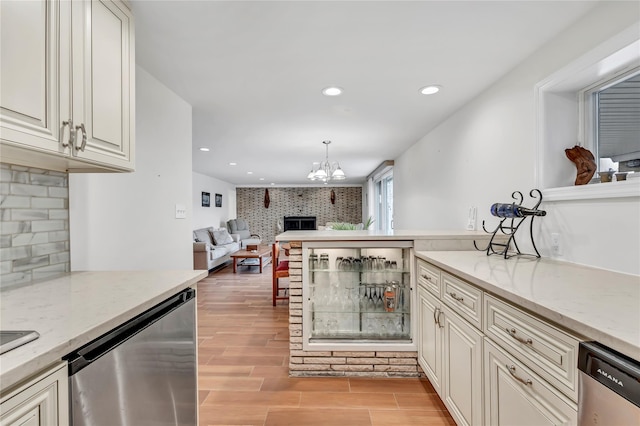 kitchen with stainless steel dishwasher, a brick fireplace, light wood finished floors, open floor plan, and recessed lighting