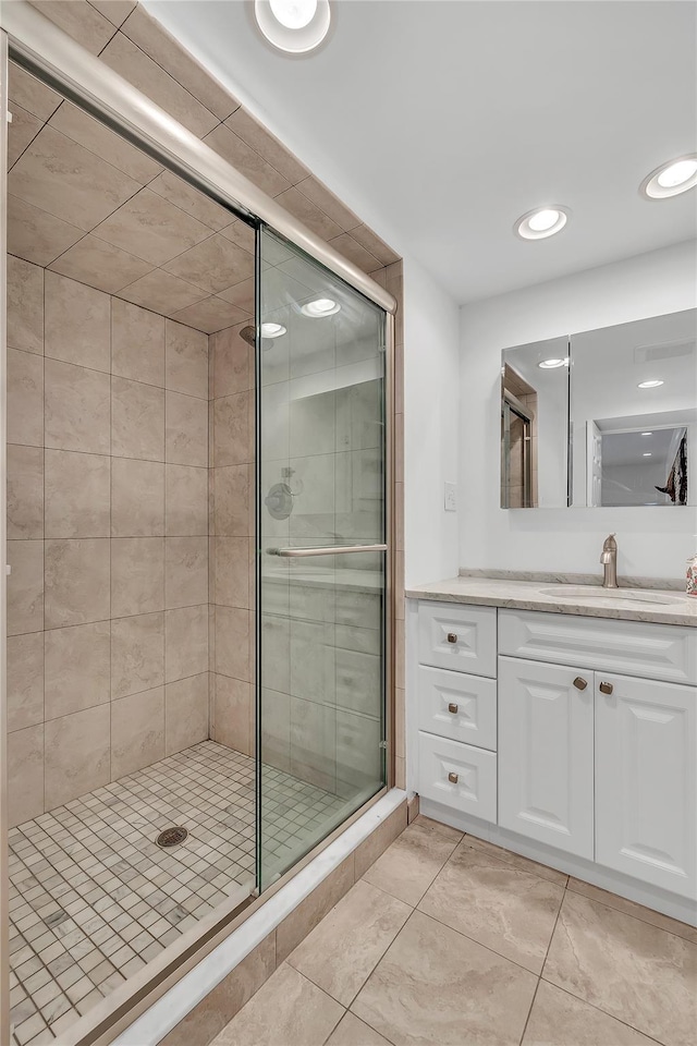 bathroom with a stall shower, tile patterned floors, vanity, and recessed lighting