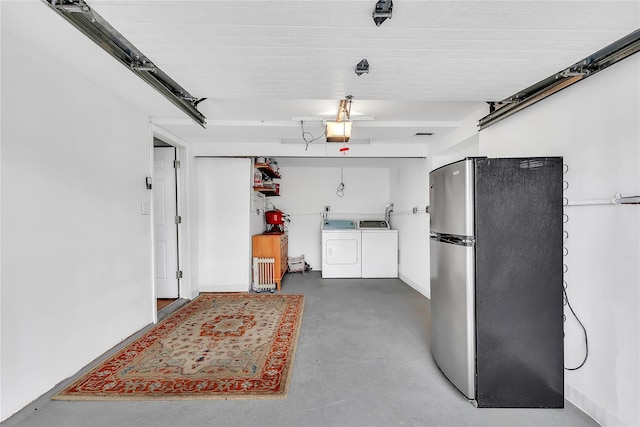 garage featuring freestanding refrigerator, washer and clothes dryer, and a garage door opener