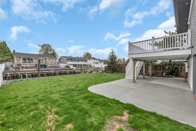view of yard featuring stairs, a patio area, a wooden deck, and a residential view