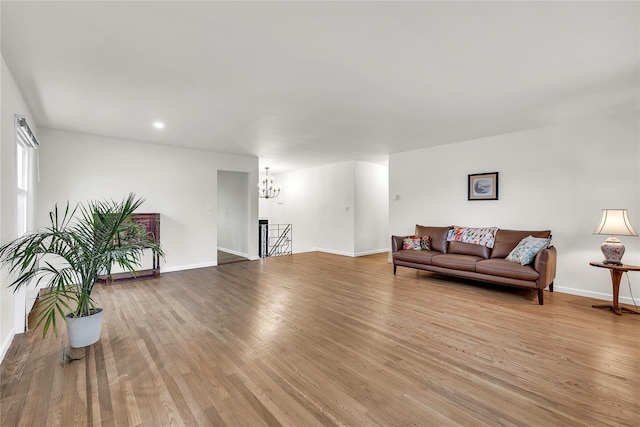 living area featuring a chandelier, wood finished floors, baseboards, and recessed lighting