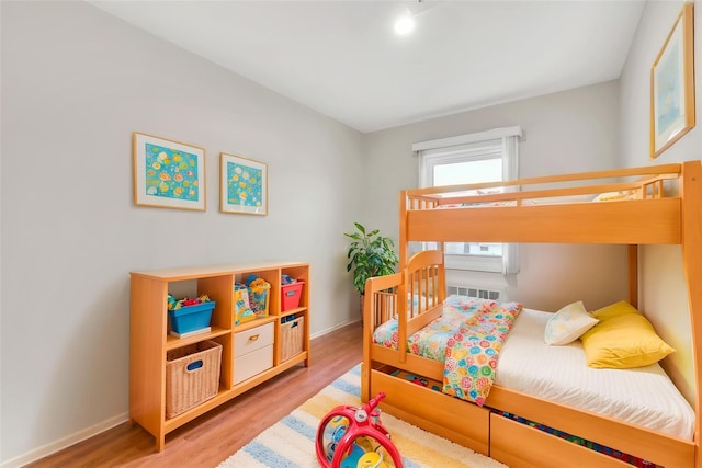 bedroom featuring light wood finished floors and baseboards