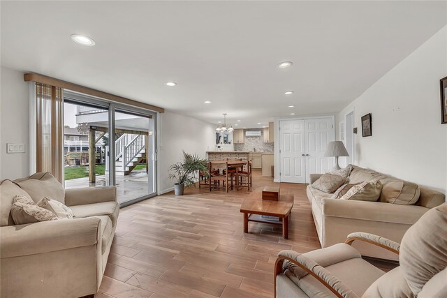 living room featuring recessed lighting, a chandelier, and light wood finished floors