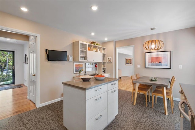 15 Scarsdale Farm Rd, Scarsdale, NY 10583 - kitchen with glass insert cabinets, pendant lighting, white cabinetry, and baseboards