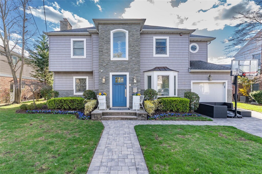 355 Church Ave, Woodmere, NY 11598 - view of front of home with a chimney, central air condition unit, stone siding, and a front yard