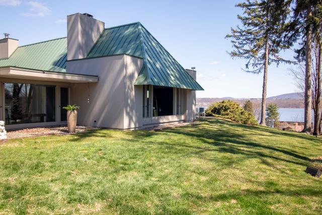 rear view of property with a chimney, a standing seam roof, and metal roof