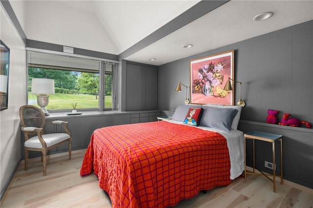 bedroom with wood finished floors and vaulted ceiling