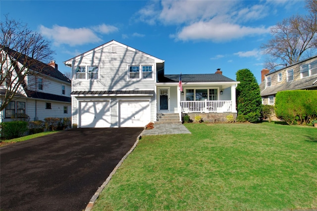 split level home with a front lawn, a garage, covered porch, and driveway