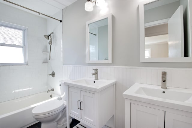 bathroom with toilet, shower / bath combination, vanity, and a wainscoted wall