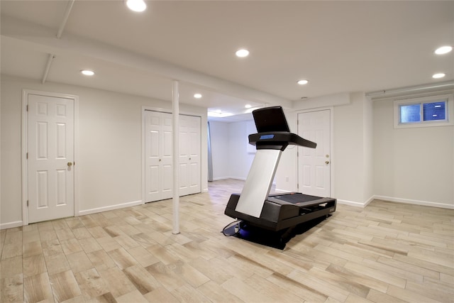 exercise room with baseboards, light wood finished floors, and recessed lighting