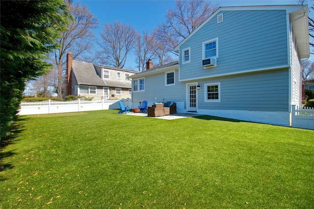 back of property with a yard, a patio area, a fenced backyard, and a chimney
