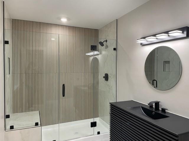 bathroom featuring a stall shower and a sink