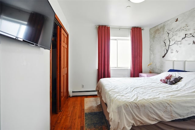 132-61 41st Rd Unit 502, Flushing, NY 11355 - bedroom featuring a baseboard heating unit, multiple windows, and wood finished floors