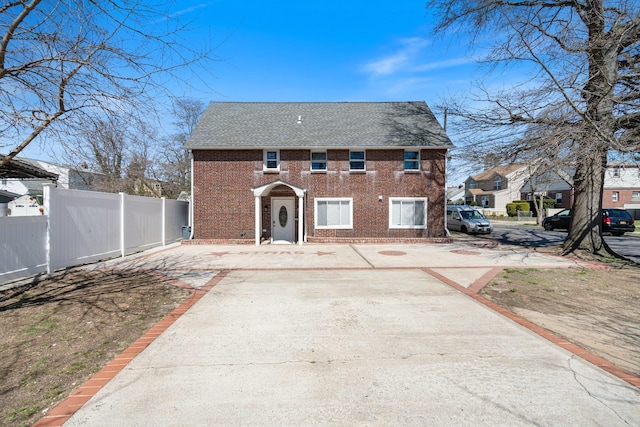208 Newport Rd, Uniondale, NY 11553 - view of front of house featuring brick siding, fence, and a shingled roof