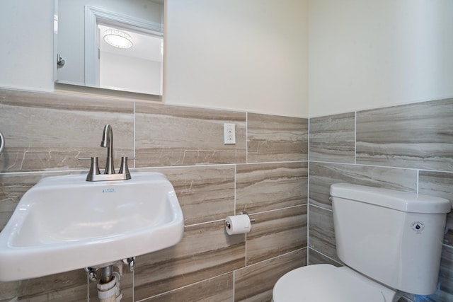 208 Newport Rd, Uniondale, NY 11553 - bathroom featuring a sink, tile walls, a wainscoted wall, and toilet