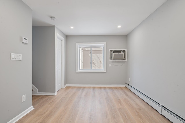 208 Newport Rd, Uniondale, NY 11553 - unfurnished room featuring baseboards, light wood-style floors, a wall unit AC, and baseboard heating