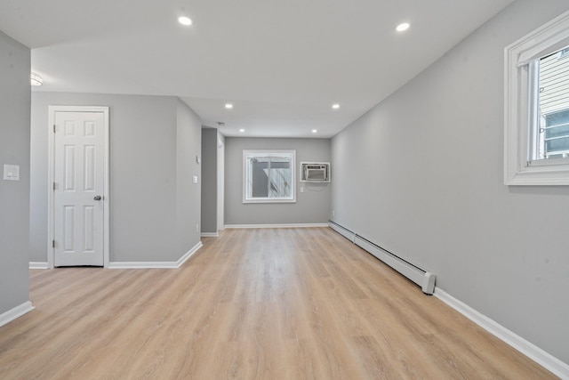 208 Newport Rd, Uniondale, NY 11553 - below grade area with baseboards, a wall mounted air conditioner, a baseboard radiator, light wood-style floors, and recessed lighting
