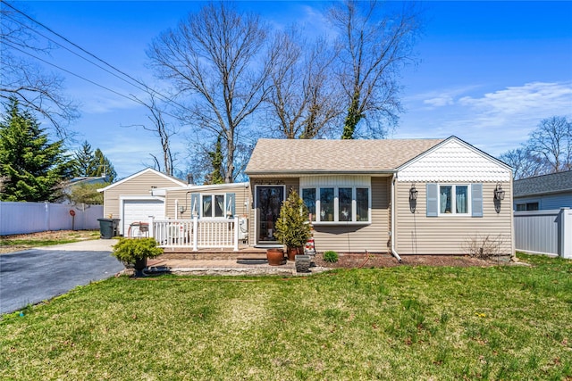 25 Snyder St, Patchogue, NY 11772 - view of front of property featuring roof with shingles, driveway, a front yard, a garage, and fence