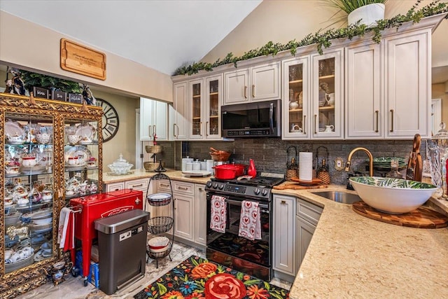 25 Snyder St, Patchogue, NY 11772 - kitchen with glass insert cabinets, a sink, gas range oven, decorative backsplash, and lofted ceiling