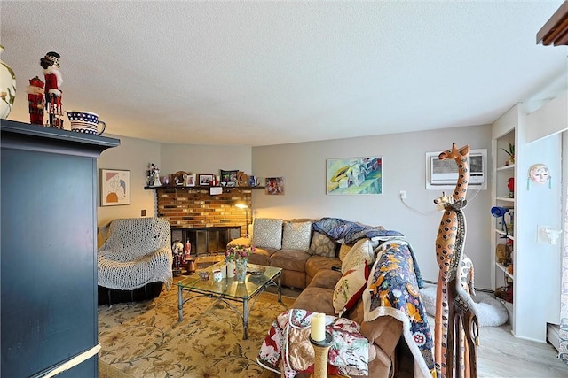 living room with wood finished floors, a textured ceiling, a brick fireplace, and a wall mounted AC