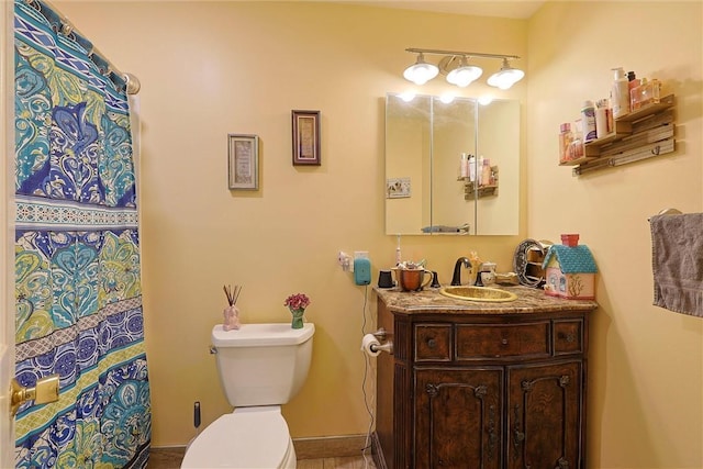 bathroom with vanity, toilet, and baseboards