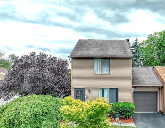 view of front of property with aphalt driveway, a shingled roof, and an attached garage