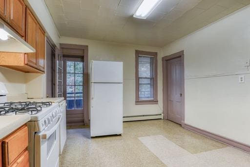kitchen with white appliances, brown cabinetry, baseboard heating, under cabinet range hood, and light countertops