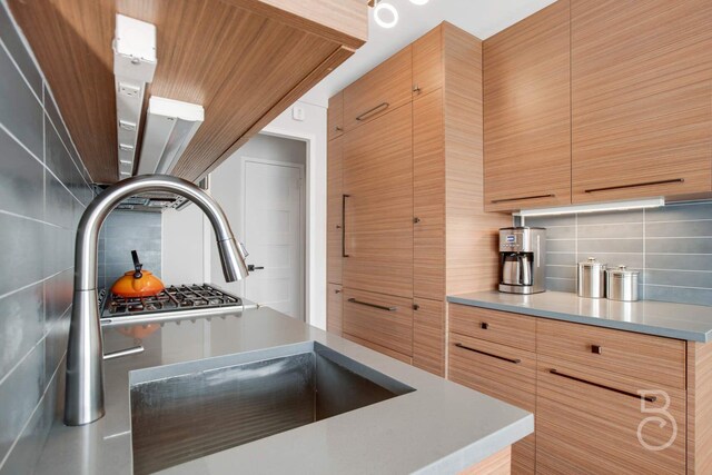 kitchen with modern cabinets, light countertops, and decorative backsplash