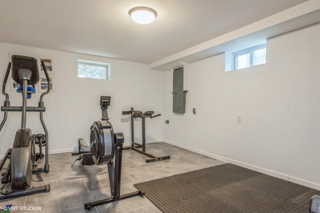 workout area featuring a healthy amount of sunlight, baseboards, and electric panel