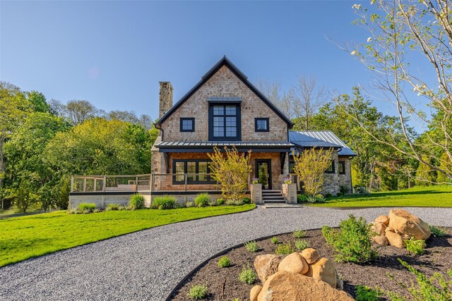 139A N Ferry Rd, Shelter Island, NY 11964 - view of front facade with a chimney, driveway, a standing seam roof, a front yard, and metal roof