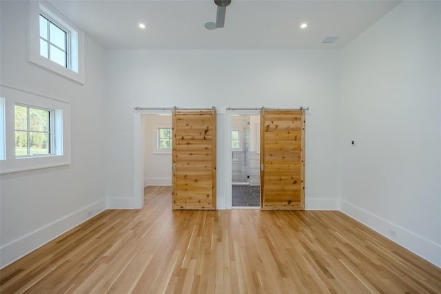 139A N Ferry Rd, Shelter Island, NY 11964 - empty room with light wood-style floors, baseboards, a barn door, and recessed lighting