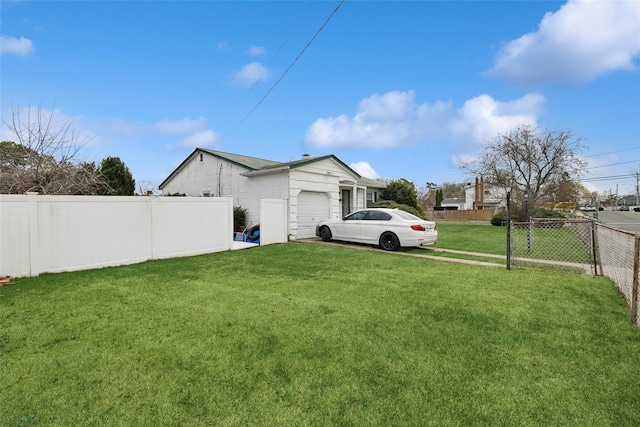 view of yard featuring an attached garage and fence