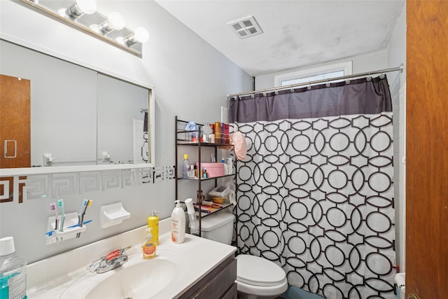 bathroom featuring toilet, a shower with curtain, vanity, and visible vents