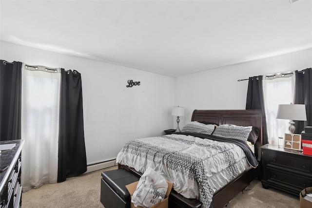 bedroom with a baseboard heating unit and light carpet